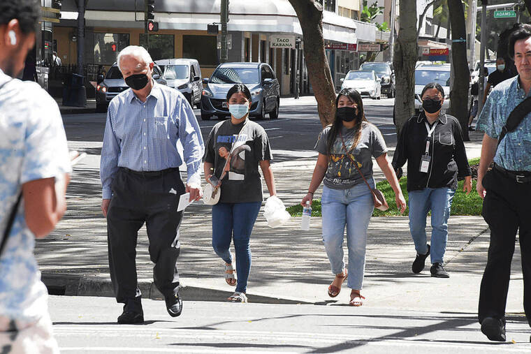 CRAIG T. KOJIMA / CKOJIMA@STARADVERTISER.COM
                                A recent survey of Hawaii residents shows strong support for continued mask-wearing for travel and other activities. Above, pedestrians on King Street crossed near Bishop Street on Tuesday.