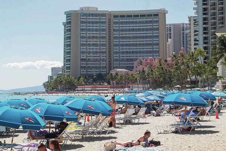 CINDY ELLEN RUSSELL / CRUSSELL@STARADVERTISER.COM
                                Hawaii is seeing stronger-than-expected visitor arrivals so far this year. Beach umbrellas lined the shores of Waikiki last week.
