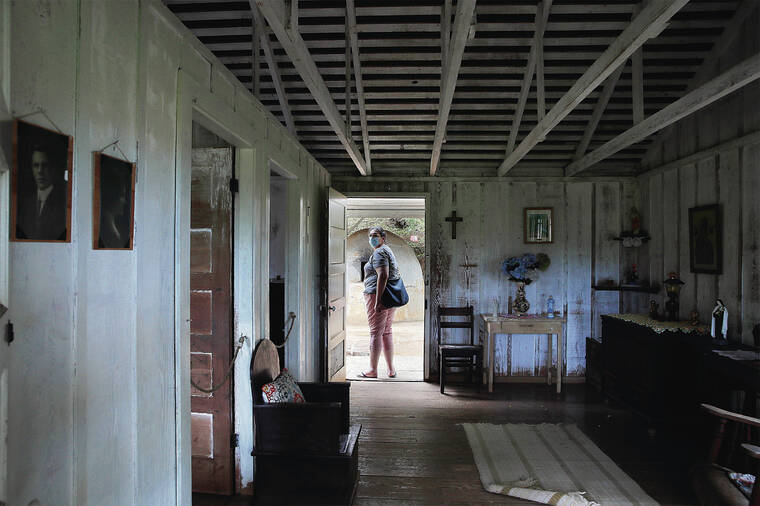 JAMM AQUINO / JAQUINO@STARADVERTISER.COM
                                A visitor stands in the doorway of the Portuguese house at the Hawaii Plantation Village.