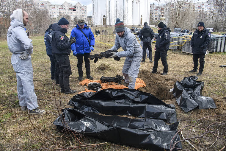 ASSOCIATED PRESS
                                French forensics investigators, who arrived to Ukraine for the investigation of war crimes amid Russia’s invasion, stand next to a mass grave in the town of Bucha, Ukraine, on April 12.