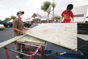 CINDY ELLEN RUSSELL / 2020
                                Jeremy Deveraturda and his son, D.J., load plywood onto his truck at Town Center of Mililani in preparation for Hurricane Douglas, which came close to making landfall on Oahu.