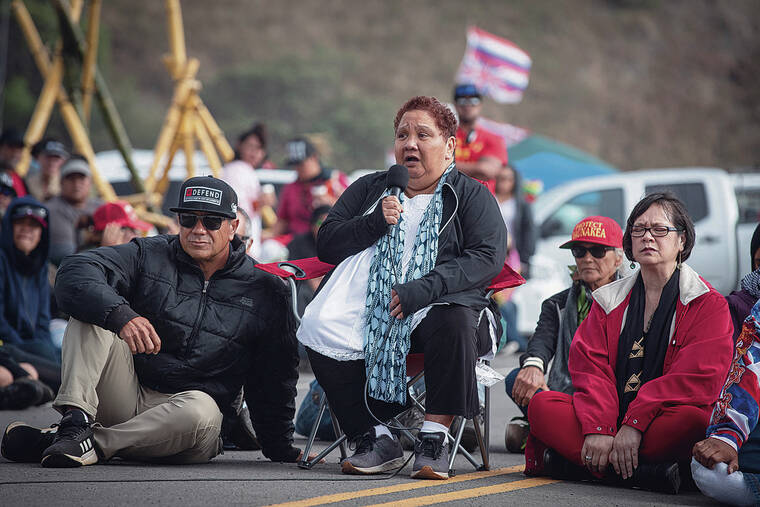 CINDY ELLEN RUSSELL / 2019
                                Officials from the Office of Hawaiian Affairs made a visit in July 2018 to kupuna blockading construction of the Thirty Meter Telescope on Mauna Kea Access Road. Addressing the kupuna and the crowd is OHA Board Chair Colette Y. Ma­chado, center, with trustee Dan Ahuna, left, and CEO Sylvia Hussey. Machado died Monday at age 71.