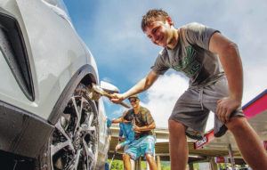 CINDY ELLEN RUSSELL / CRUSSELL@STARADVERTISER.COM
                                Washing cars while fundraising for the Mid-Pacific Institute Judo team in Kahala.