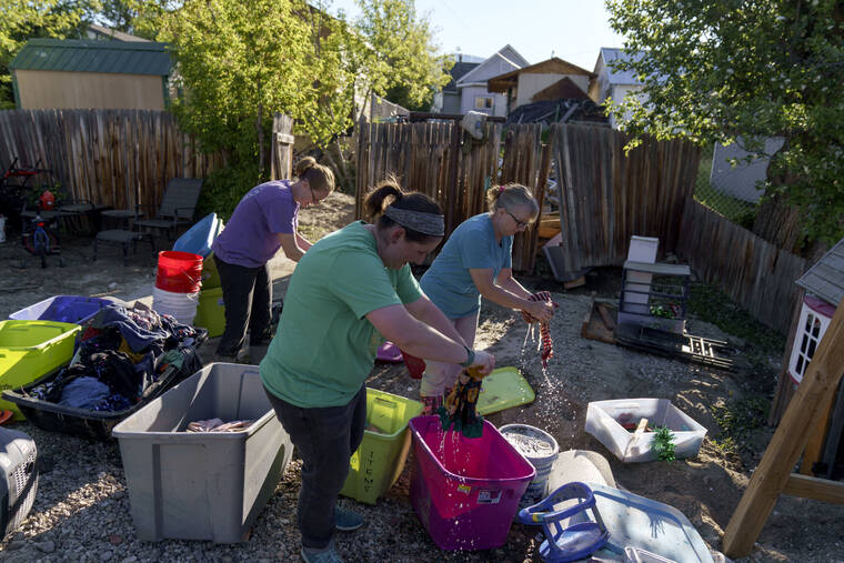 ASSOCIATED PRESS / JUNE 15
                                Kirstyn Brown, left, cleans out damaged clothing from her flooded home with the help of her mother, Cheryl Pruitt, right, and her sister-in-law, Randi Pruitt, in Red Lodge, Mont., Wednesday.