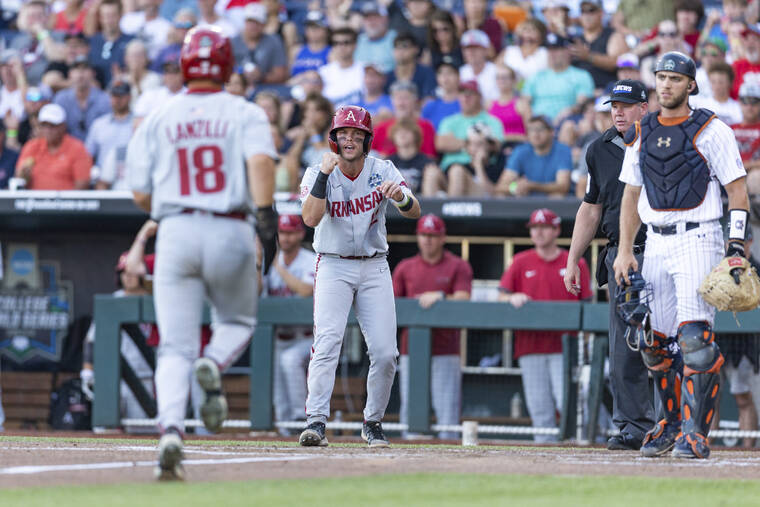 ASSOCIATED PRESS
                                Arkansas’ Michael Turner (12) scores and cheers on Chris Lanzilli (18) running home for a second run against Auburn in the third inning.