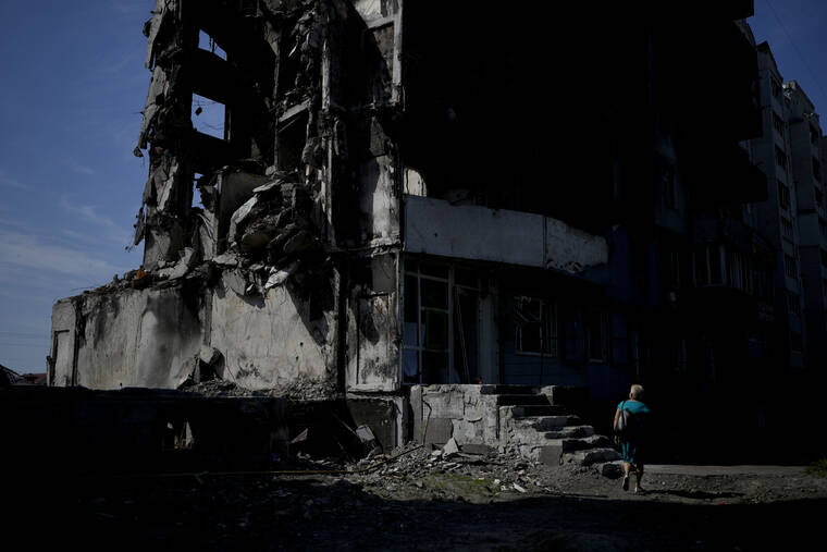 ASSOCIATED PRESS
                                A woman walks past a building destroyed in Russian shelling in Borodyanka, on the outskirts of Kyiv, Ukraine, today.