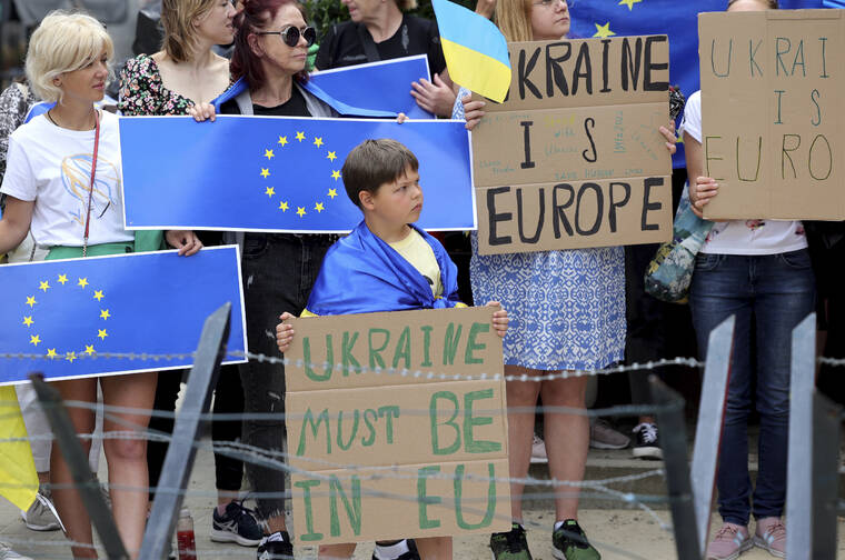 ASSOCIATED PRESS
                                Protestors in support of Ukraine stand with signs and EU flags during a demonstration outside of an EU summit in Brussels, today. European Union leaders are expected to approve Thursday a proposal to grant Ukraine a EU candidate status, a first step on the long toward membership.