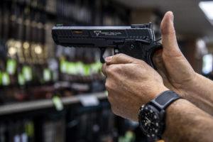 BRITTAINY NEWMAN / AP
                                A customer checks out a hand gun that is for sale and on display at SP firearms on Thursday, June 23, in Hempstead, New York.