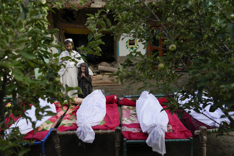 ASSOCIATED PRESS
                                Afghans stand by the bodies of relatives killed in an earthquake in Gayan village, in Paktika province, Afghanistan, on Thursday.