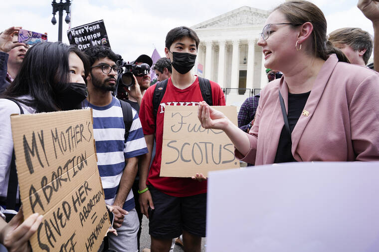 ASSOCIATED PRESS
                                Abortion-rights activists, at left, confront anti-abortion activists, at right, react following Supreme Court’s decision to overturn Roe v. Wade in Washington, today. The Supreme Court has ended constitutional protections for abortion that had been in place for nearly 50 years, a decision by its conservative majority to overturn the court’s landmark abortion cases.