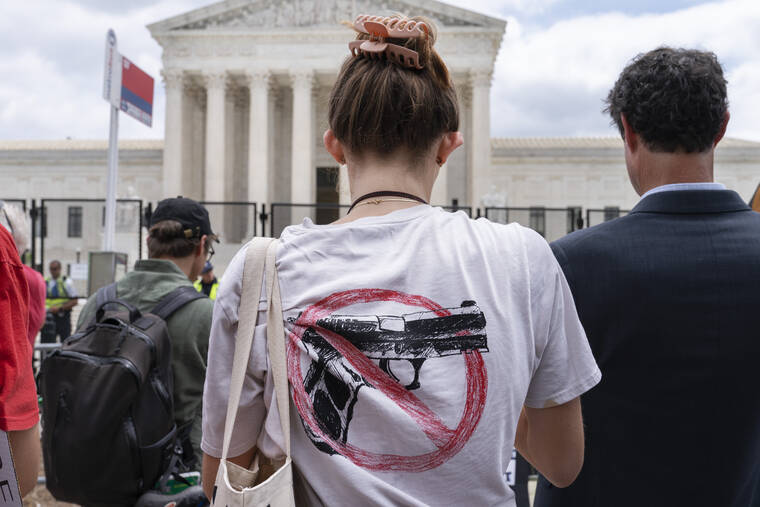 ASSOCIATED PRESS
                                A woman wears an anti-gun T-shirt outside of the Supreme Court, following the Supreme Court’s decision to overturn Roe v. Wade in Washington on Friday.