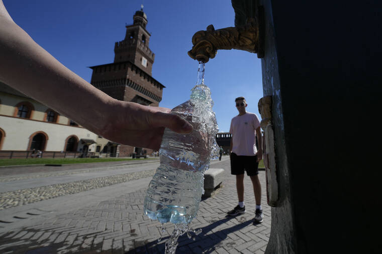 Tourists fill plastic bottles with water from a public fountain at the Sforzesco Castle, in Milan, Italy, Saturday, June 25, 2022. The mayor of Milan signed an ordinance Saturday turning off public decorative fountains and limiting water sprinklers in Italy's business capital as northern Italy endures one of the worst droughts in decades. The city ordinance follows the declaration Friday of a state of emergency in the surrounding Lombardy region, which has endured an unusually early heatwave and months without significant rainfall. Neighboring Emilia Romagna and Piemonte have undertaken similar crisis measures. (AP Photo/Luca Bruno)