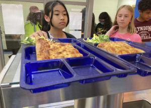 ASSOCIATED PRESS
                                Students get lunch of homemade pizza and caesar salad at the Albert D. Lawton Intermediate School, in Essex Junction, Vt., June 9. The pandemic-era federal aid that made school meals available for free to all public school students — regardless of family income levels — is ending, raising fears about the effects in the upcoming school year for families already struggling with rising food and fuel costs.