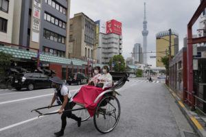 ASSOCIATED PRESS
                                A rickshaw puller carries his customers around Tokyo’s Asakusa area famous for sightseeing, Wednesday. Japan is bracing for a return of tourists from abroad, as border controls to curb the spread of coronavirus infections are gradually loosened.
