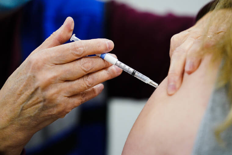 ASSOCIATED PRESS
                                A health worker administers a dose of a COVID-19 vaccine during a vaccination clinic at the Keystone First Wellness Center in Chester, Pa., on Dec. 15. Government advisers are debating, today, if Americans should get a modified COVID-19 booster shot this fall — one that better matches more recent virus variants.