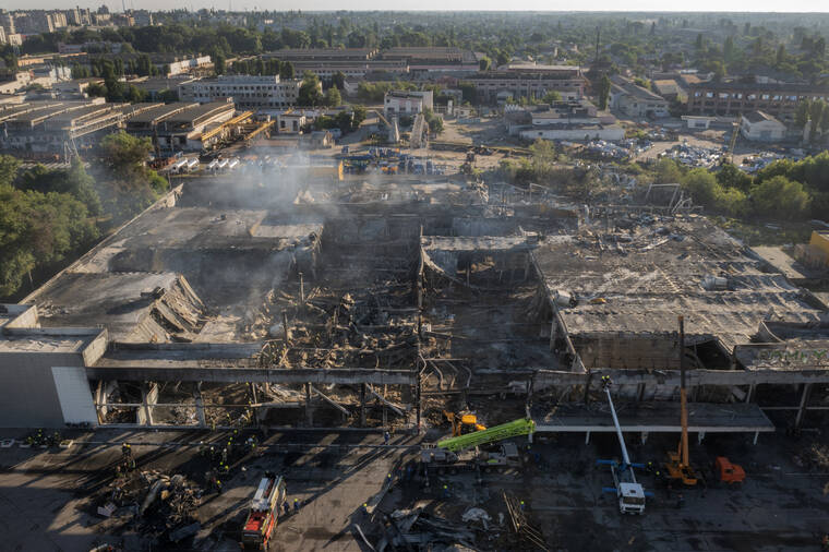 ASSOCIATED PRESS
                                Ukrainian State Emergency Service firefighters work to take away debris at a shopping center burned after a rocket attack in Kremenchuk, Ukraine, today.