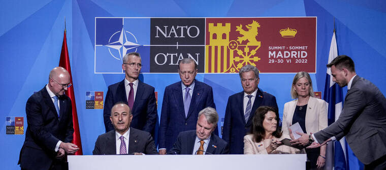 BERNAT ARMANGUE / AP
                                From left to right background: NATO Secretary General Jens Stoltenberg, Turkish President Recep Tayyip Erdogan, Finland’s President Sauli Niinisto, Sweden’s Prime Minister Magdalena Andersson, Turkish Foreign Minister Mevlut Cavusoglu, Finnish Foreign Minister Pekka Haavisto, and Sweden’s Foreign Minister Ann Linde sign a memorandum in which Turkey agrees to Finland and Sweden’s membership of the defense alliance in Madrid, Spain on Tuesday.