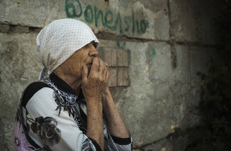 ASSOCIATED PRESS
                                An elderly Ukrainian woman looks on after Russian shelling in Mykolaiv, Ukraine, today.