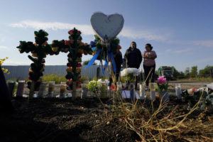 ERIC GAY / AP
                                Mourners pay their respects at a makeshift memorial at the site where officials found dozens of people dead in an abandoned semitrailer containing suspected migrants, Wednesday, in San Antonio.