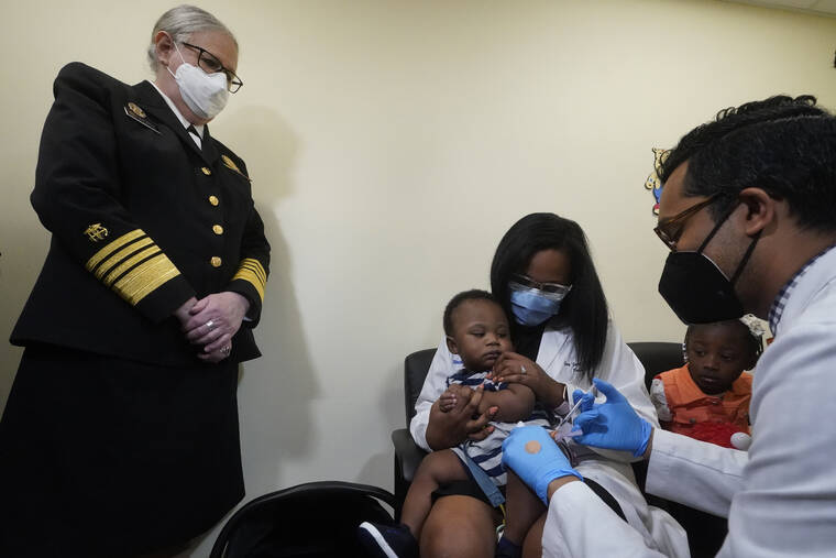 ASSOCIATED PRESS
                                Pediatrician Emy Jean-Marie, center, holds her nine-month-old son Adedeji Adebayo, Emiola Adebayo, 3, on her lap as Dr. Nizar Dowla, right, administers a vaccine while Department of Health and Human Services Assistant Secretary for Health, Admiral Rachel Levine, left, looks on, Tuesday, at the Borinquen Health Care Center in Miami.