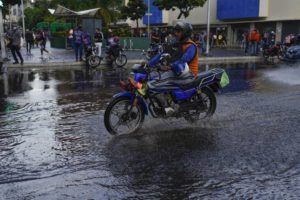ASSOCIATED PRESS / JUNE 29
                                A man rides his motorcycle over a puddle in Caracas, Venezuela, Wednesday.