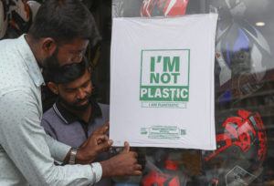 ASSOCIATED PRESS
                                Workers of a helmet store paste degradable plastic substitute material on a glass in Hyderabad, India.