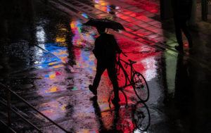 ASSOCIATED PRESS / MAY 9
                                <strong>SPLASHY STROLL</strong>: With the Tokyo rainy season in full swing, a man walks with his bicycle along a street made vibrant by city lights and the wet weather.