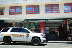JAMM AQUINO / JAQUINO@STARADVERTISER.COM
                                Law enforcement officers are seen outside Pinky’s Hempire as Dept. Of Health officials secure items inside.