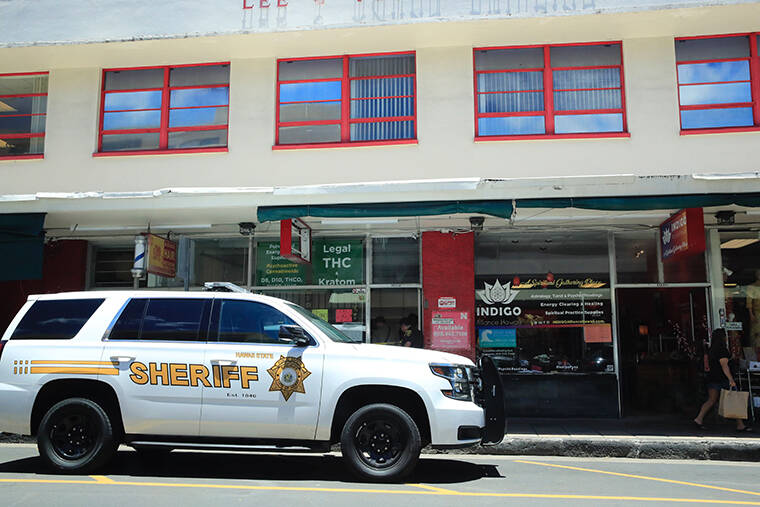 JAMM AQUINO / JAQUINO@STARADVERTISER.COM
                                Law enforcement officers are seen outside Pinky’s Hempire as Department of Health officials secure items inside.