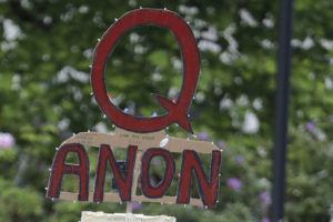 ASSOCIATED PRESS / 2020
                                A person carries a sign supporting QAnon during a protest rally in Olympia, Wash.