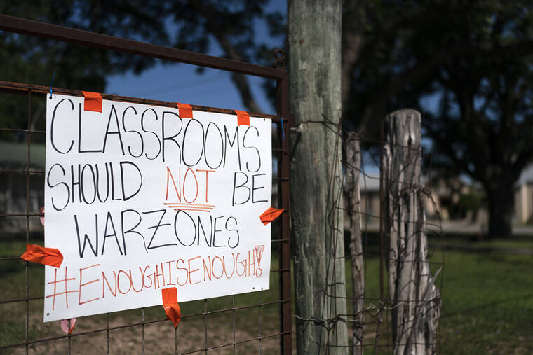 ASSOCIATED PRESS
                                A sign asking for a change hangs on a fence near Robb Elementary School in Uvalde, Texas, on Friday.