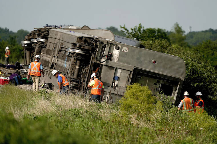 ASSOCIATED PRESS
                                Workers inspect the scene of an Amtrak train which derailed after striking a dump truck near Mendon, Mo.