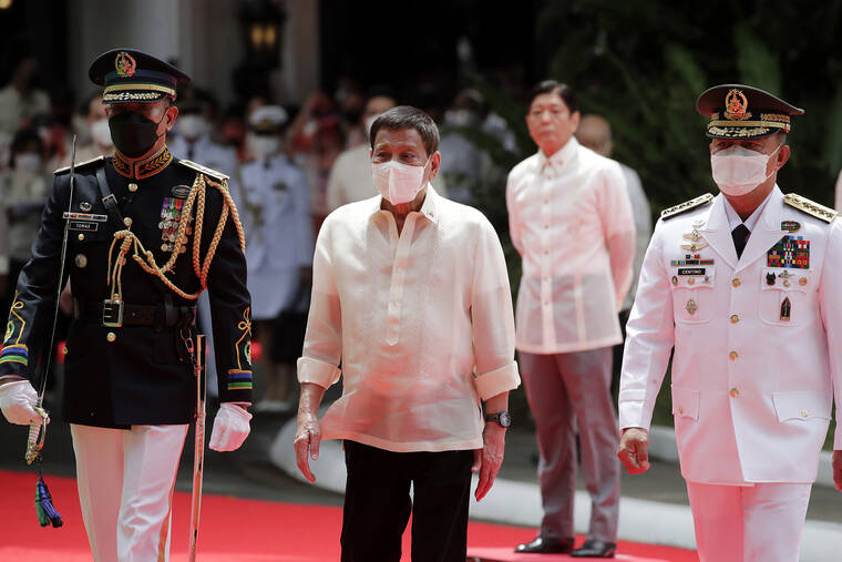 POOL VIA AP
                                Outgoing Philippines president Rodrigo Duterte, center, is escorted as he reviews an honor guard as incoming President Ferdinand Marcos Jr., second right, looks on during his inauguration ceremony at the Malacanang Presidential Palace grounds in Manila, Philippines.
