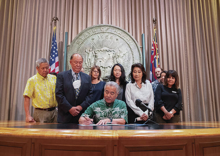 CINDY ELLEN RUSSELL / CRUSSELL@STARADVERTISER.COM
                                Governor David Ige signs a bill on Wednesday to raise the minimum wage to $18 per hour by Jan. 1, 2028.