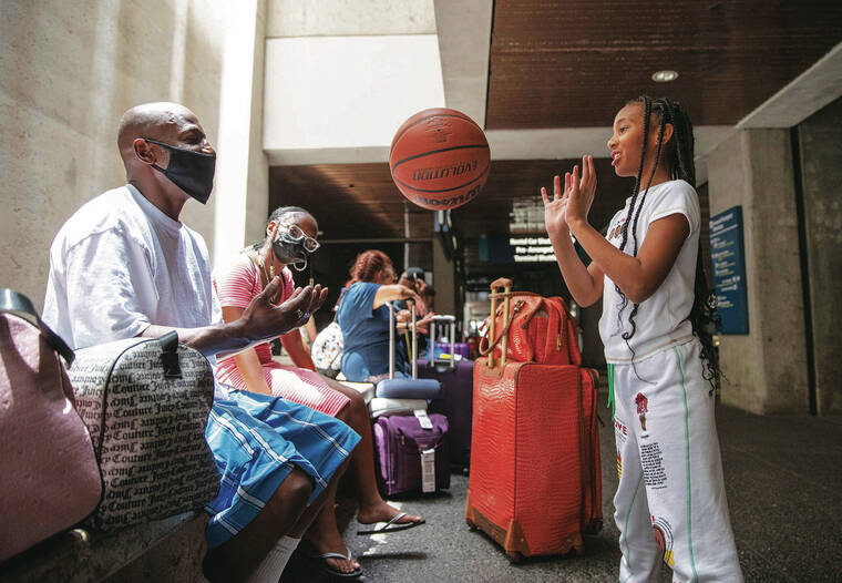 CINDY ELLEN RUSSELL / CRUSSELL@STARADVERTISER.COM
                                At top, Ray Alexander played “hot potato” with Raylany Alexander, 10, while waiting for a pickup Thursday at Daniel K. Ino­uye International Airport. Also pictured is Melanie Rothchild.