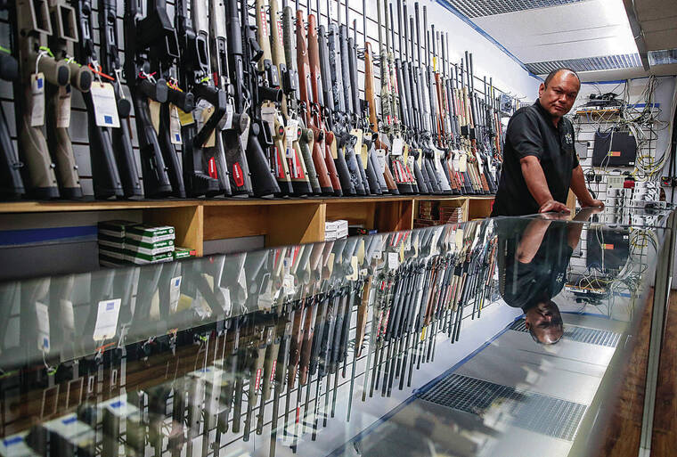 JAMM AQUINO / JAQUINO@STARADVERTISER.COM
                                The U.S. Supreme Court struck down a New York state law Thursday that had restricted who could obtain a permit to carry a gun in public. Above, 808 Gun Club co-owner Tom Tomimbang stands by one of the display cases with handguns for purchase on Thursday.