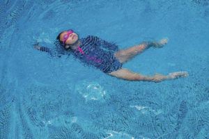CRAIG T. KOJIMA/CKOJIMA@STARADVERTISER.COM
                                A young girl seems to strike a pose while swimming.