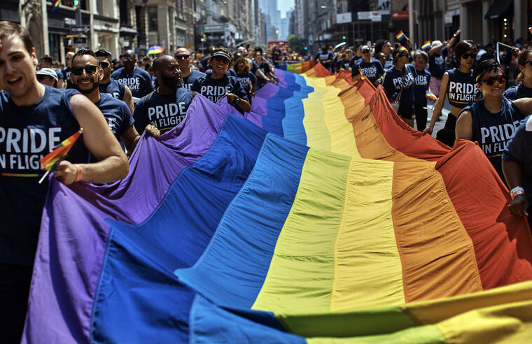 ASSOCIATED PRESS
                                Reveler carry a LGBTQ flag along Fifth Avenue during the New York City Pride Parade on Sunday in New York.