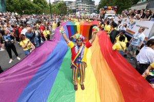 PA / AP
                                Mohammed Nazir from London, poses on a giant rainbow flag, during the Pride in London parade, in London, Saturday, marking the 50th Anniversary of the Pride movement in the U.K.