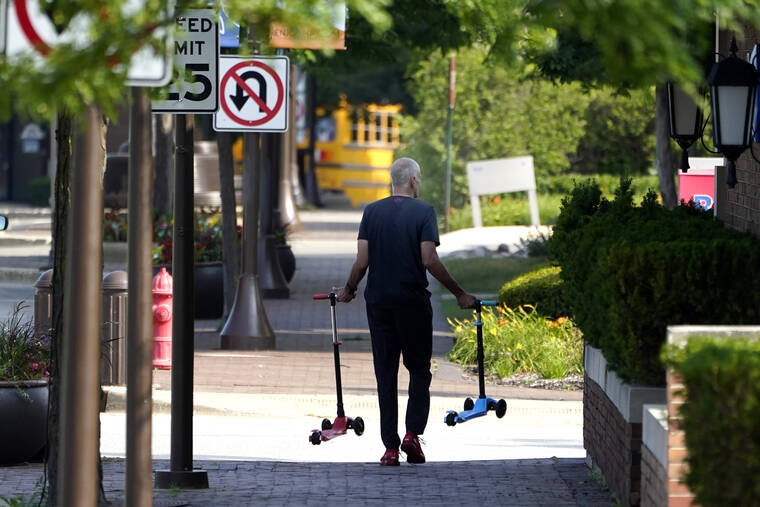 ASSOCIATED PRESS
                                A man removes two children’s scooters one day after a mass shooting in downtown Highland Park, Ill., today. A shooter fired on an Independence Day parade from a rooftop spraying the crowd with gunshots initially mistaken for fireworks before hundreds of panicked revelers of all ages fled in terror.