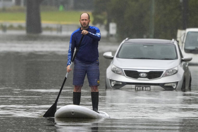ASSOCIATED PRESS
                                A man paddles on a stand-up paddle board through a flooded street at Windsor on the outskirts of Sydney, Australia, Tuesday. Hundreds of homes have been inundated in and around Australia’s largest city in a flood emergency that was impacting 50,000 people, officials said Tuesday.