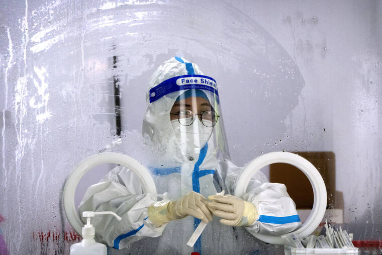 ASSOCIATED PRESS
                                A worker wearing a protective suit waits to administer a COVID-19 test at a coronavirus testing site in Beijing, Wednesday. Residents of parts of Shanghai and Beijing have been ordered to undergo further rounds of COVID-19 testing following the discovery of new cases in the two cities, while additional restrictions remain in place in Hong Kong, Macao and other cities.