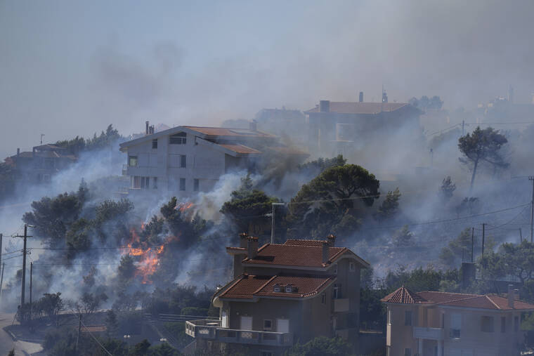 THANASSIS STAVRAKIS / AP
                                Fire burns next to houses in the area of Drafi east of Athens on Wednesday. Hundreds of people were evacuated from their homes late Tuesday as a wildfire threatened mountainside suburbs northeast of Athens. Firefighters battled through the night, struggling to contain the blaze which was being intensified by strong gusts of wind.