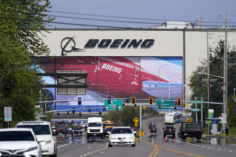 ASSOCIATED PRESS / 2021 Traffic drives in view of a Boeing Co. production plant, where images of jets decorate the hangar doors in Everett, Wash. Roughly 2,500 Boeing workers are expected to go on strike the following month at three plants in the St. Louis area after they voted Sunday, July 24, 2022, to reject a contract offer from the plane maker.