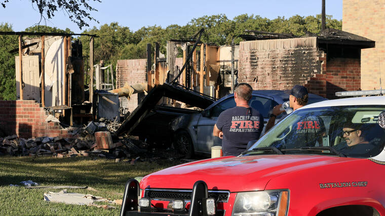 THE DALLAS MORNING NEWS / AP
                                Balch Spring fire fighters look over the remains of a house, Tuesday, July 26, in Balch Springs, Texas.
