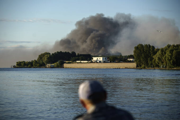 ASSOCIATED PRESS
                                A fisherman watches smoke rise after Russian forces launched a missile attack on a military unit in the Vyshhorod district on the outskirts of Kyiv, Ukraine, today.