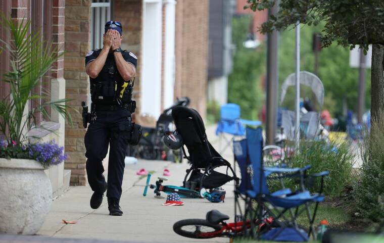 BRIAN CASSELLA/CHICAGO TRIBUNE VIA ASSOCIATED PRESS
                                A Lake County police officer walks down Central Ave in Highland Park, Ill., today, after a shooter fired on the northern suburb’s Fourth of July parade.