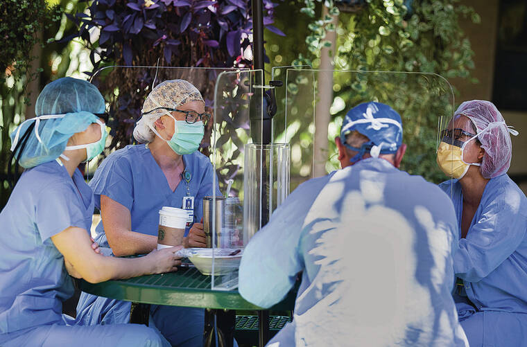 CINDY ELLEN RUSSELL / 2020 
                                The COVID-19 pandemic has led to a shortage of health care workers in Hawaii’s hospitals. Medical staff take a break outdoors together outside The Queen’s Medical Center.