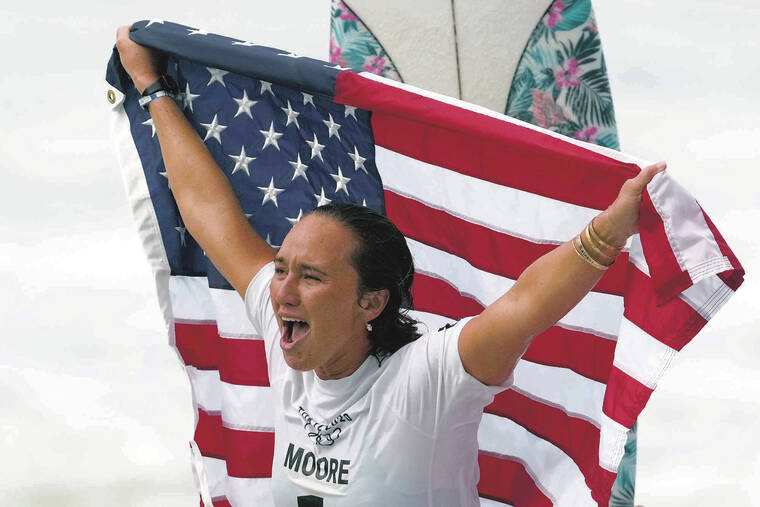 ASSOCIATED PRESS
                                Carissa Moore held up the American flag while celebrating her gold medal-winning performance at the Summer Olympics at Tsurigasaki beach in Ichinomiya, Japan, on July 27, 2021.