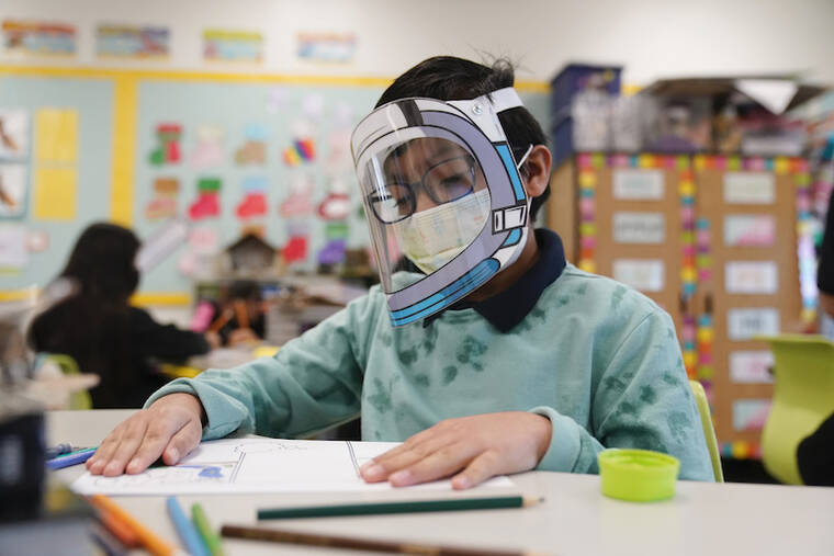 ASSOCIATED PRESS / JAN. 12
                                FILE - A student wears a mask and face shield in a 4th grade class amid the COVID-19 pandemic at Washington Elementary School in Lynwood, Calif.